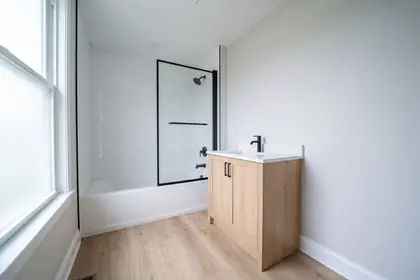 Representative stock photograph — renovated bathroom with a tiled tub surround. Not a photograph of any asset in this panel.